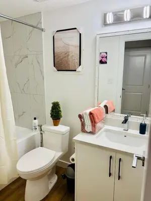 a bathroom with a toilet and a sink and a mirror at Charming Stay & Cozy Retreat by Bansari Homes in Edmonton- YEG in Edmonton