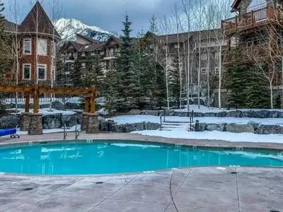 a swimming pool in a yard with snow on the ground at Breathtaking Luxury 3Bd Penthouse Pool and Hot Tub in Canmore