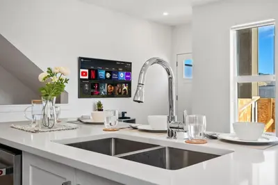 a white kitchen with a sink and a sink at Luxury Aspen 2BR Home with Double Garage Car Parking in Calgary