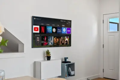 a tv hanging on a wall in a living room at Luxury Aspen 2BR Home with Double Garage Car Parking in Calgary