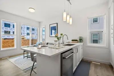 a kitchen with a large white counter top and windows at Luxury Aspen 2BR Home with Double Garage Car Parking in Calgary