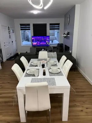 a white dining table and chairs in a living room at Elegant 3BD Home in Beaumont, Double Garage in Nisku
