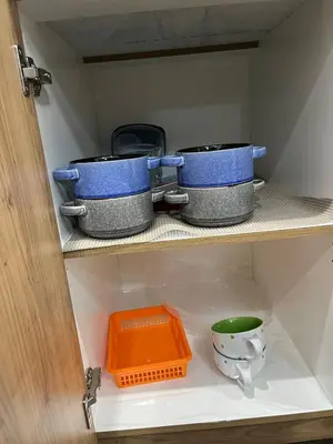 three pots and pans on a shelf in a cabinet at Elegant 3BD Home in Beaumont, Double Garage in Nisku