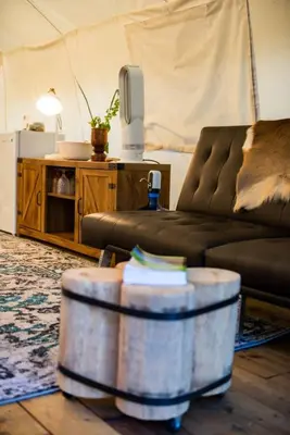 a living room with a couch and a table at Haida Gwaii Glamping in Tlell