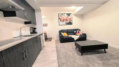 a kitchen and a living room with a couch at Luxury Modern 2-Bedroom Suite in Airdrie