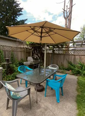 a patio table and chairs with an umbrella at Calm, cozy, urban, family-friendly stay in Vancouver