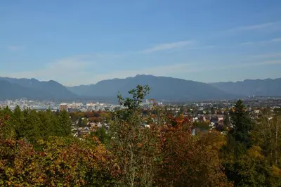 a view of a city with mountains in the background at Calm, cozy, urban, family-friendly stay in Vancouver