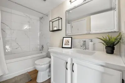 a white bathroom with a sink and a toilet at Winter Prices Reduced for Stylish Condo & Easy to Mountains ! in Calgary