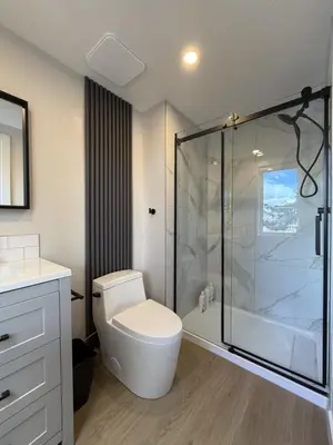 a bathroom with a toilet and a glass shower at Memory Lodge in Canmore