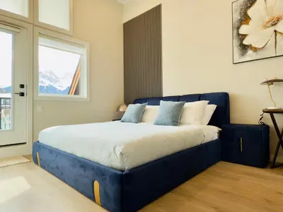 a blue bed in a room with a window at Memory Lodge in Canmore
