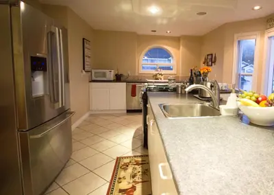 a kitchen with a stainless steel refrigerator and a sink at Eagle Close Executive B&B in Prince Rupert