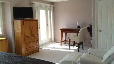 a bedroom with a desk and a bed with a television at Eagle Close Executive B&B in Prince Rupert