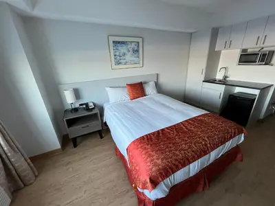 a small bedroom with a bed and a table at The Lodge Inn in Edmonton