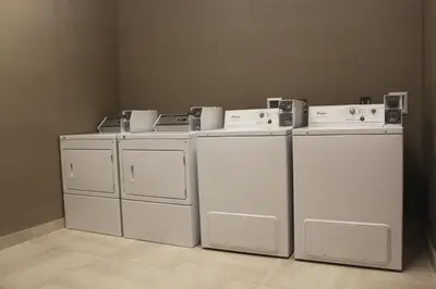 a group of white washers and dryers in a room at Meridian Inn & Suites Lloydminster in Lloydminster