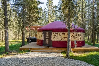 a yurt in the woods with a red roof at Shanti Yurt with private hot tub in Bragg Creek in Bragg Creek