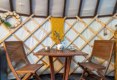 a table and two chairs in front of a wall at Shanti Yurt with private hot tub in Bragg Creek in Bragg Creek