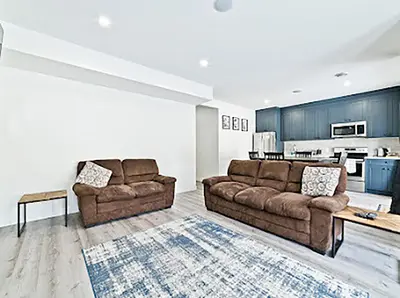 a living room with two couches and a kitchen at Cozy two bed apartment in Calgary