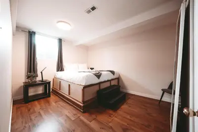a bedroom with a bed and a wooden floor at The Cloud off 16th - 2bd 1 ba in Calgary
