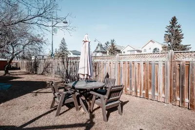 a table with an umbrella and two chairs next to a fence at The Cloud off 16th - 2bd 1 ba in Calgary