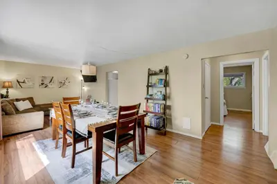 a dining room and living room with a table and chairs at Dreams off 16th in Calgary