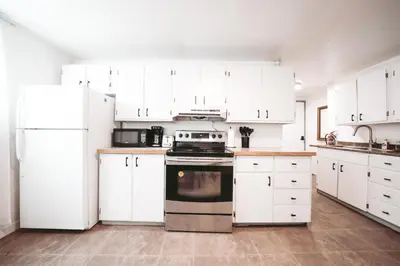 a kitchen with white appliances and white cabinets at Dreams off 16th in Calgary