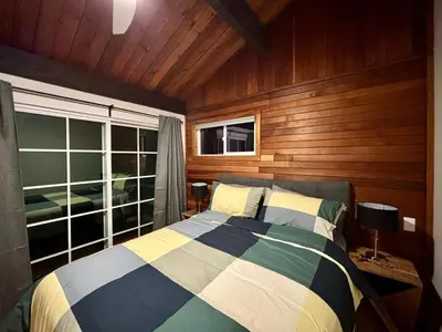 a bedroom with a bed and a large window at Gambier Lavender Lodge and Homestead in Gibsons