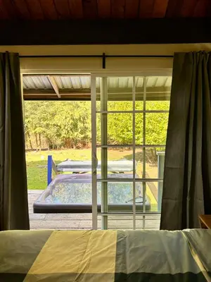 a bedroom with a view of a pool through a window at Gambier Lavender Lodge and Homestead in Gibsons