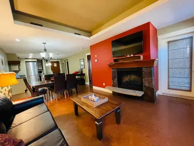 a living room with a couch and a fireplace with a tv at Solara Getaway 2BR Condo with Pool - Hot Tub - Gym - Spa in Canmore