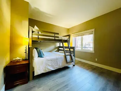 a bedroom with a bunk bed in a yellow wall at Solara Getaway 2BR Condo with Pool - Hot Tub - Gym - Spa in Canmore