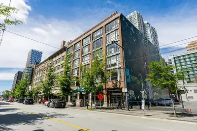 a large building on a city street with cars parked in front at Gorgeous Unit in the Heart of Downtown in Vancouver