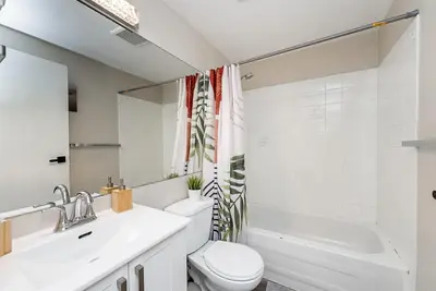 a white bathroom with a toilet and a sink at Gorgeous Unit in the Heart of Downtown in Vancouver