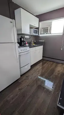 a kitchen with a white refrigerator and white cabinets at Deerview Lodge & Cabins - Princeton BC in Princeton
