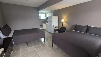 a bedroom with a bed and a table and a refrigerator at Deerview Lodge & Cabins - Princeton BC in Princeton