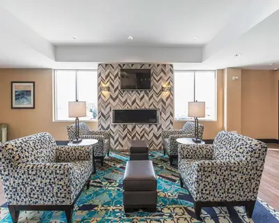 a living room with two chairs and a fireplace at Comfort Inn & Suites Airport North in Calgary