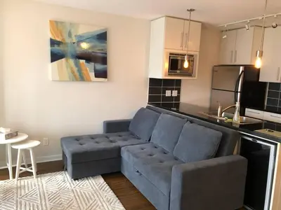a living room with a couch and a kitchen at Downtown Apartment in Vancouver