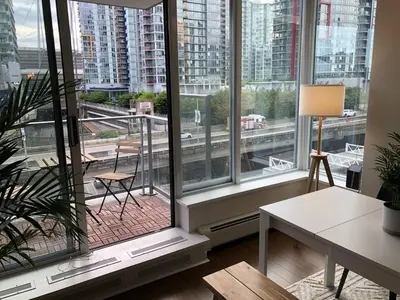 a room with a large window with a view of a city at Downtown Apartment in Vancouver