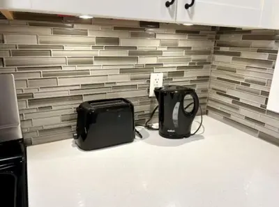 a kitchen with two appliances sitting on the floor at Modern 3BR Near Airport & DT in Calgary