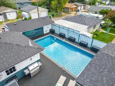 an overhead view of a swimming pool between two houses at The Experience - Pool Hot Tub Theater Games Rm Pub in Calgary