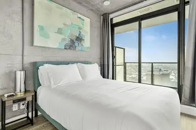 a bedroom with a large bed and a large window at Executive Sky LUX - 2 BD 2BA Views Pool Patio & Gym in Calgary