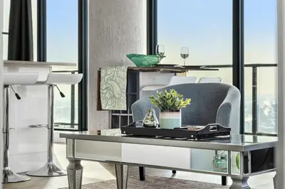 a living room with a table and a chair at Executive Sky LUX - 2 BD 2BA Views Pool Patio & Gym in Calgary