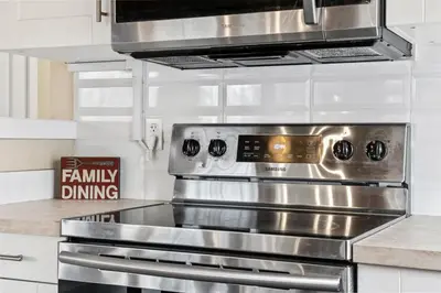 a stainless steel oven in a kitchen with white cabinets at Lake Vibes 3 BD 1 BA Cottage steps from the Lake in Lacombe