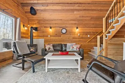 a living room with a couch and a table at Lake Vibes 3 BD 1 BA Cottage steps from the Lake in Lacombe
