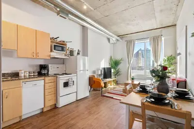 a kitchen with white appliances and a table with chairs at Eminence Sleek Studio City View in Edmonton