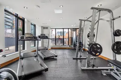 a gym with two treadmills and two tread machines at Miso 2 BD - Skyline View Patio Gym Pool & AC in Calgary