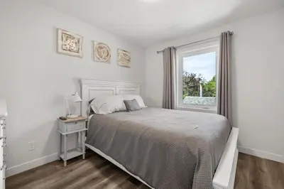 a white bedroom with a bed and a window at Winston Suite 2BR 1BA - Carriage Suite with Garage in Calgary