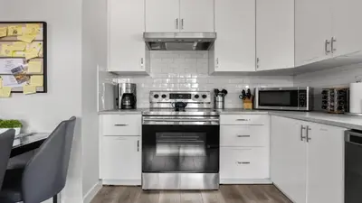 a kitchen with white cabinets and a stainless steel oven at Winston Suite 2BR 1BA - Carriage Suite with Garage in Calgary
