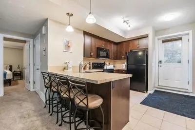 a kitchen with a large island with bar stools at The Trenta - 4BD 3BA 2 Kitchen Stunner in Calgary