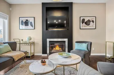 a living room with a fireplace and a tv at The Trenta - 4BD 3BA 2 Kitchen Stunner in Calgary