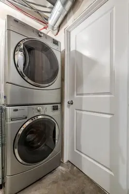 a laundry room with a washer and dryer next to a door at The Trenta - 4BD 3BA 2 Kitchen Stunner in Calgary
