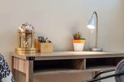 a wooden desk with a lamp and plants on it at The Grande 1BD 1BA - Full Kitchen Guest Suite in Calgary